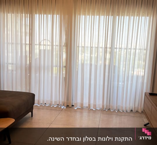וילון לבן שקוף תלוי על חלון גדול